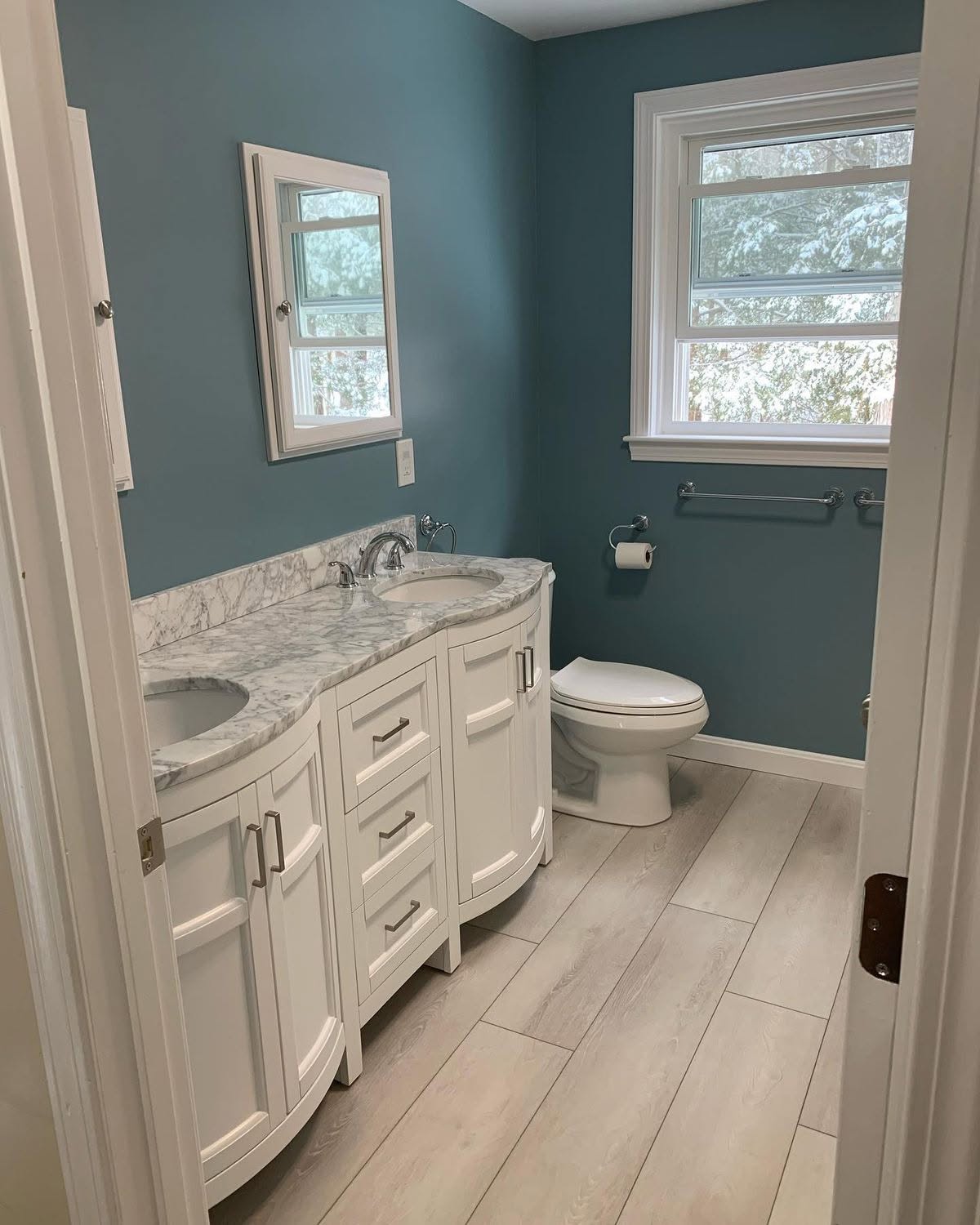 Bright bathroom with white vanity and blue walls.