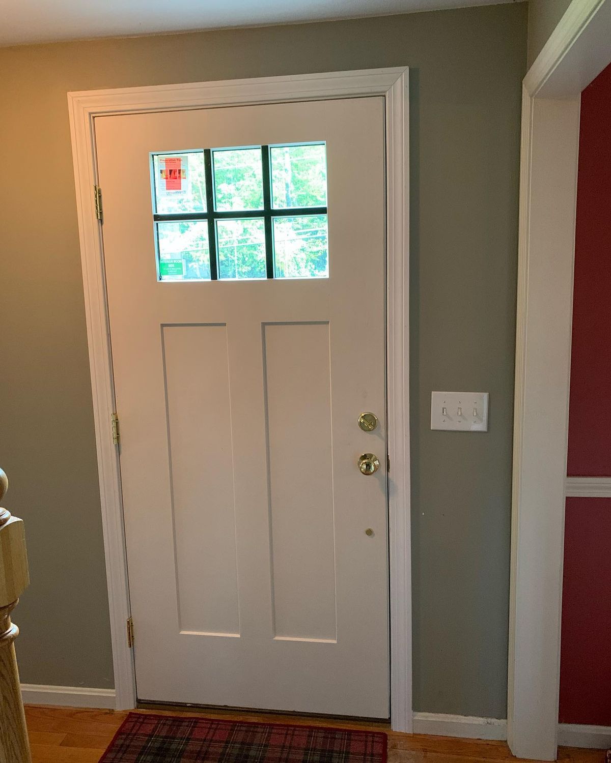 A beige front door with a window and two locks.