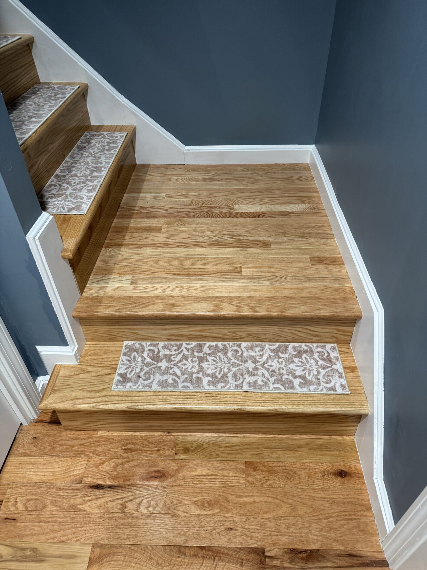 Wooden staircase with a decorative stone strip on one step.