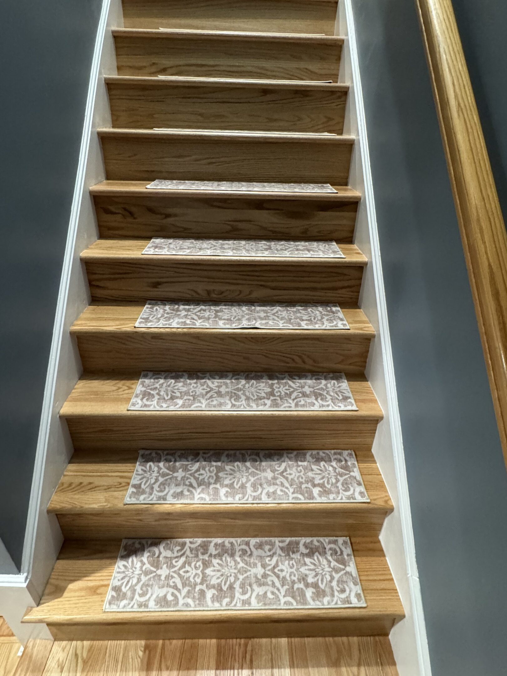 Wooden staircase with patterned carpet runners on each step.