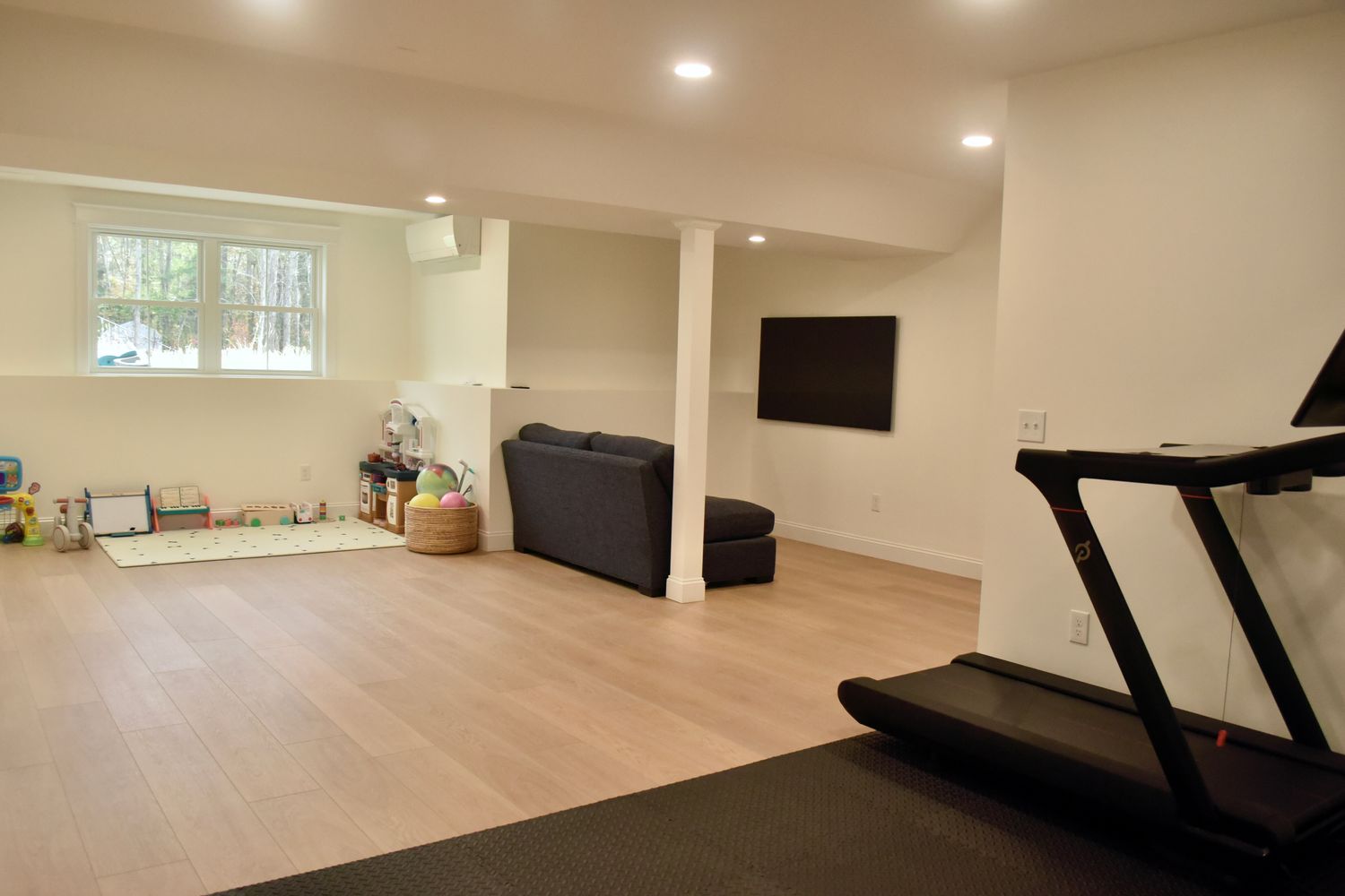 Modern living room with minimalist furniture and light wood flooring.