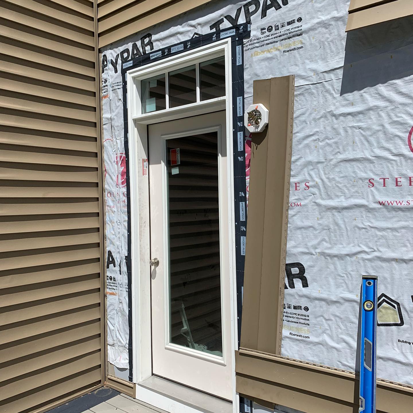 Newly installed white door with glass panel in a house under renovation.