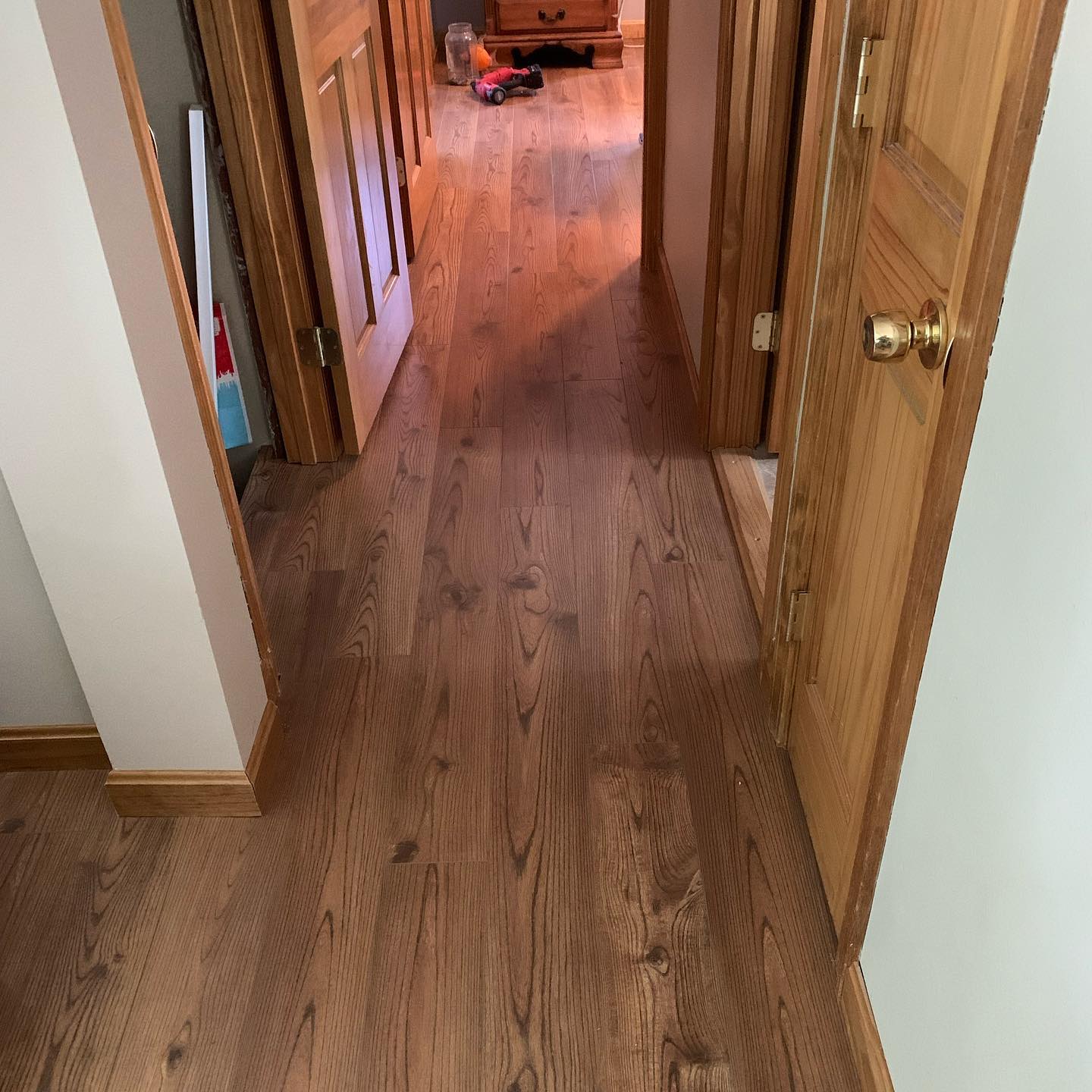 Wooden floor hallway with doors on both sides.