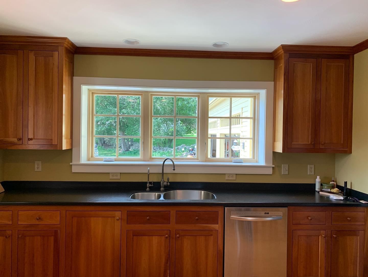 Modern kitchen with wooden cabinets and a large window above the sink.