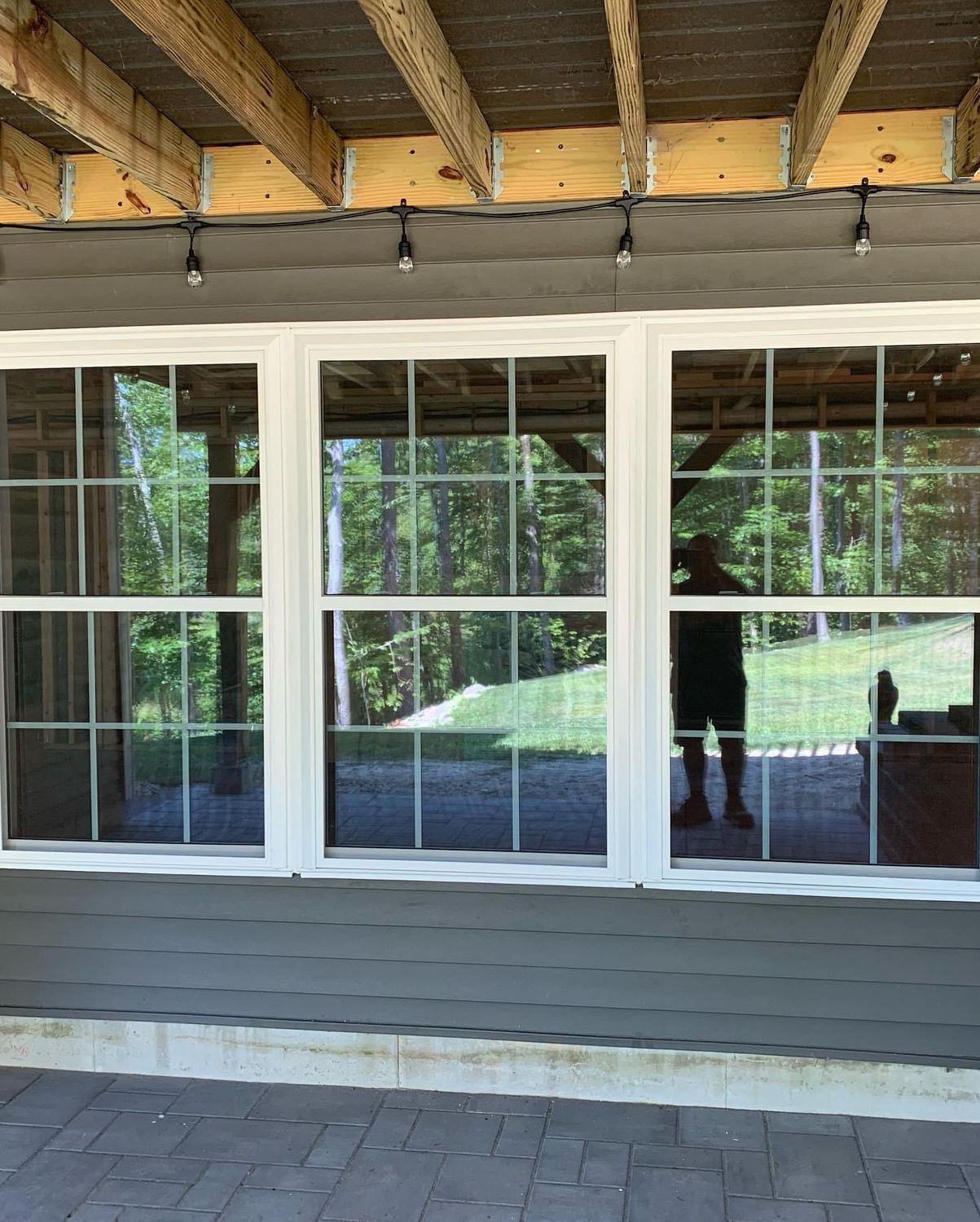 Large window with white frame overlooking a green outdoor area.