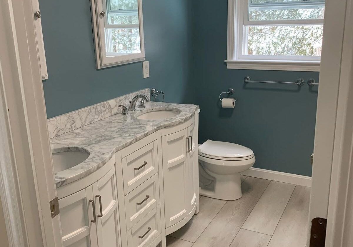 Bright bathroom with white vanity and blue walls.
